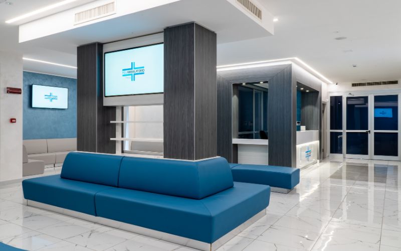 Sala d'attesa con divani blu e reception